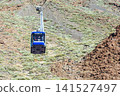 Blue cabin cable car with tourists climbing ropes stretched to the volcano Teide on Tenerife island. 141527497