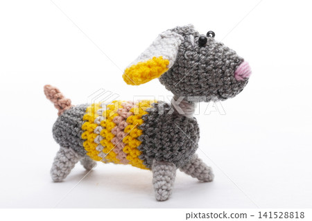 Knitted woolen dog on a white background Knitted woolen dog on a white background 141528818