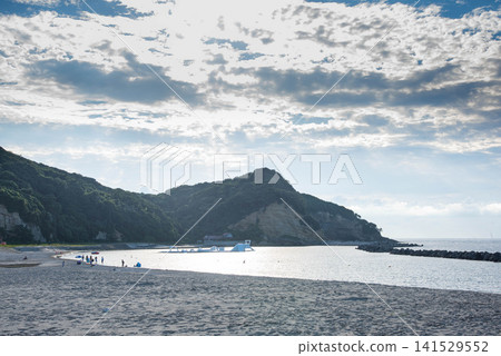 一片被夏日晴空和青山環繞的海灘。 一片被夏日晴空和青山環繞的海灘。 141529552