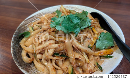 Spicy knife-cut noodles topped with cilantro Spicy knife-cut noodles topped with cilantro 141529587