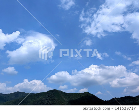 A landscape of cumulonimbus clouds and mountain ranges spreading across the summer sky. A landscape of cumulonimbus clouds and mountain ranges spreading across the summer sky. 141529717