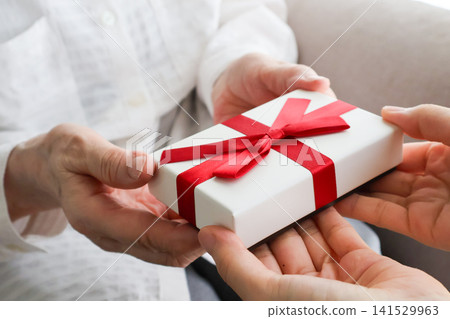Image for Respect for the Aged Day: A scene of giving a gift to a senior woman. 141529963