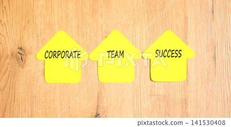 Corporate team success symbol. Concept words Corporate team success on beautiful yellow paper houses. Beautiful wooden background. Business corporate team success concept. Copy space. 141530408