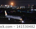A passenger plane being towed away for a night flight 141530482
