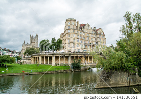 Bath, a city in the UK registered as a World Heritage Site, boasts a large river and historic honey-colored stone buildings along its banks. Bath, a city in the UK registered as a World Heritage Site, boasts a large river and historic honey-colored stone buildings along its banks. 141530551