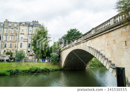 Bath, a city in the UK registered as a World Heritage Site, boasts a large river and historic honey-colored stone buildings along its banks. Bath, a city in the UK registered as a World Heritage Site, boasts a large river and historic honey-colored stone buildings along its banks. 141530555