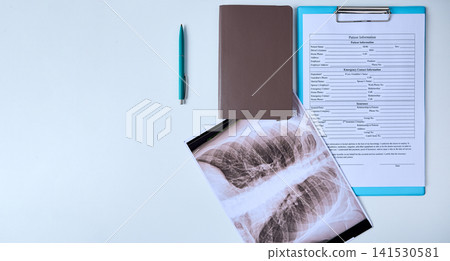 Chest X-ray and patient information form are placed on a table of medical clinic 141530581