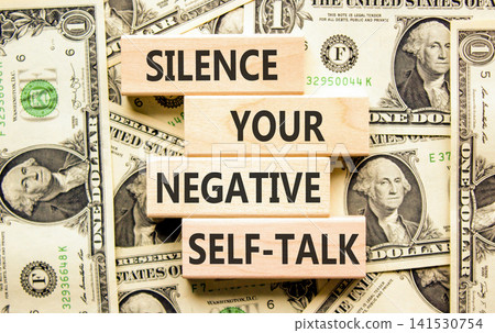 Silence your negative self-talk symbol. Concept words Silence your negative self-talk on beautiful wooden blocks. Beautiful dollar bills background. Psychological negative self-talk concept Copy space Silence your negative self-talk symbol. Concept words Silence your negative self-talk on beautiful wooden blocks. Beautiful dollar bills background. Psychological negative self-talk concept Copy space 141530754