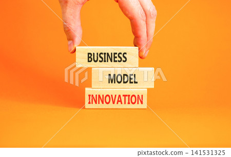 Business model innovation words symbol. Concept words Business model innovation on beautiful wooden blocks. Beautiful orange background. Businessman hand. Business model innovation concept Copy space Business model innovation words symbol. Concept words Business model innovation on beautiful wooden blocks. Beautiful orange background. Businessman hand. Business model innovation concept Copy space 141531325