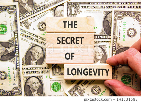 The secret of longevity symbol. Concept words The secret of longevity on beautiful wooden blocks. Beautiful dollar bills background. Psychological medical the secret of longevity concept. Copy space. The secret of longevity symbol. Concept words The secret of longevity on beautiful wooden blocks. Beautiful dollar bills background. Psychological medical the secret of longevity concept. Copy space. 141531585