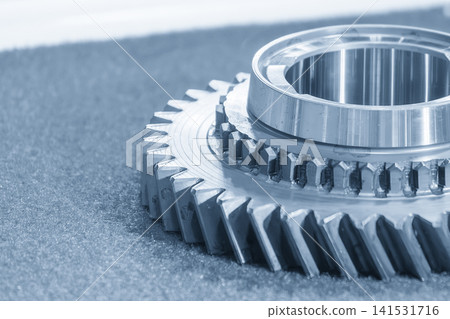 Macro close-up of used transmission bevel gear parts in an industrial blue tone environment. 141531716