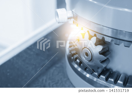 Close-up of a reverse direction gear set in a blue tone scene with dramatic lighting effects. Close-up of a reverse direction gear set in a blue tone scene with dramatic lighting effects. 141531719