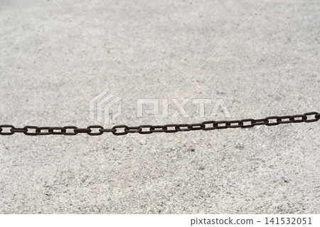 Rusty Metal Chain Across Concrete Surface Rusty Metal Chain Across Concrete Surface 141532051