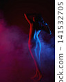 Sensual silhouette of woman's back in vibrant red and blue neon light with atmospheric smoke 141532705
