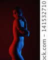 Artistic silhouette of female body in neon red and blue light on dark background 141532710