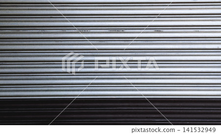 Silver and black metal roller shutter door texture background in horizontal view. Horizontal abstract metal rolling shutter door texture background in silver and black tone for web banner and design. Silver and black metal roller shutter door texture background in horizontal view. Horizontal abstract metal rolling shutter door texture background in silver and black tone for web banner and design. 141532949