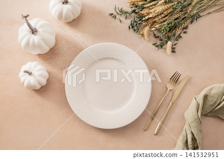 Autumn table setting with white plates pumpkins and dried flowers flat lay Autumn table setting with white plates pumpkins and dried flowers flat lay 141532951