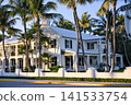 Colonial House Facade Along A Palm Lined Street With Holiday Wreaths 141533754