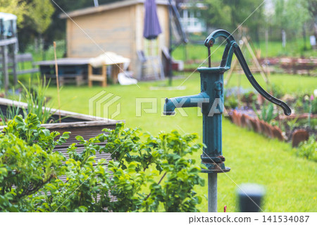 Vintage Hand Water Pump in Green Garden Vintage Hand Water Pump in Green Garden 141534087