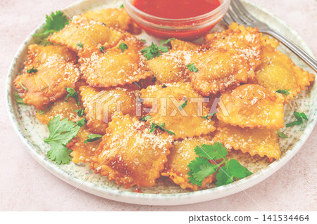 fried ravioli with parmesan cheese, served with red sauce and garnished with herbs, on a light background, no people, fried ravioli with parmesan cheese, served with red sauce and garnished with herbs, on a light background, no people, 141534464