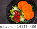 crispy fried fish cutlets, fish burgers, on a black plate, with fresh lettuce leaves, arugula and cherry tomatoes, homemade, no people, 141534466