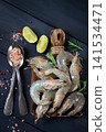 Fresh raw, white-footed shrimp, tiger prawns vannamei, on a wooden cutting board, with lime slices, and seasonings, 141534471