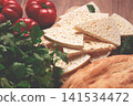 Georgian sliced cheese,on a wooden chopping board, with tomatoes with herbs and lavash, rustic style, Georgian cuisine, no people 141534472