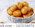 Baked new potatoes, with butter and dill, on a white plate, at home, no people, 141534474