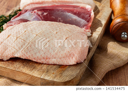 Fresh raw duck breast, on a wooden chopping board, top view, no people, Fresh raw duck breast, on a wooden chopping board, top view, no people, 141534475