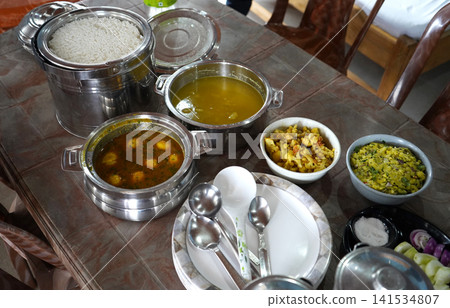 Indian meal of rice, dal, potato curry, and alu bharta on a table Indian meal of rice, dal, potato curry, and alu bharta on a table 141534807