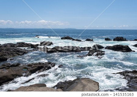 洶湧的海浪拍打著三浦半島城島的岩石,激起陣陣海浪。 洶湧的海浪拍打著三浦半島城島的岩石,激起陣陣海浪。 141535163