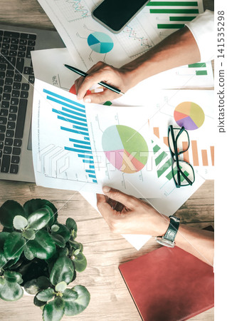 Businessperson studies colorful data charts in a tidy office 141535298