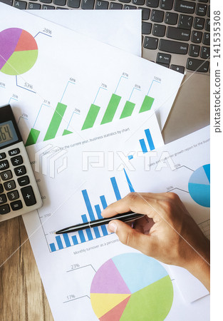 Close-up of hand pointing at charts Close-up of hand pointing at charts 141535308