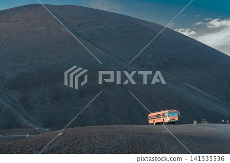 Cerro Negro at sunset, viewed from below. Landscape of Cerro Negro alongside a tourist bus. Cerro Negro at sunset, viewed from below. Landscape of Cerro Negro alongside a tourist bus. 141535536