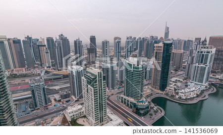 Aerial top view of Dubai Marina night to day timelapse. Modern towers and traffic on the road 141536069