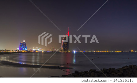 Dubai skyline with Burj Al Arab hotel day to night timelapse. Dubai skyline with Burj Al Arab hotel day to night timelapse. 141536113
