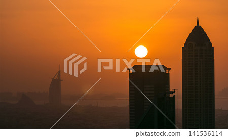 Aerial view of a big modern city with sunset timelapse. Business bay, Dubai, United Arab Emirates. Aerial view of a big modern city with sunset timelapse. Business bay, Dubai, United Arab Emirates. 141536114