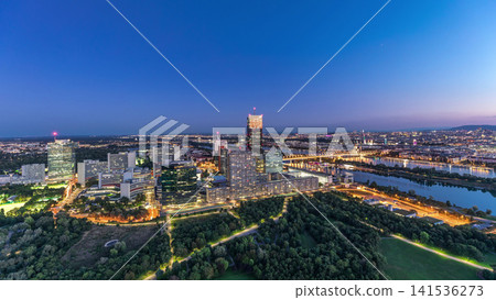 Aerial panoramic view over Vienna city with skyscrapers, historic buildings and a riverside promenade day to night timelapse in Austria. Aerial panoramic view over Vienna city with skyscrapers, historic buildings and a riverside promenade day to night timelapse in Austria. 141536273