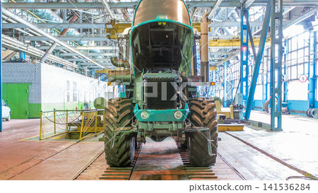 Conveyor assembly stage the body of tractor at big industrial factory timelapse Conveyor assembly stage the body of tractor at big industrial factory timelapse 141536284