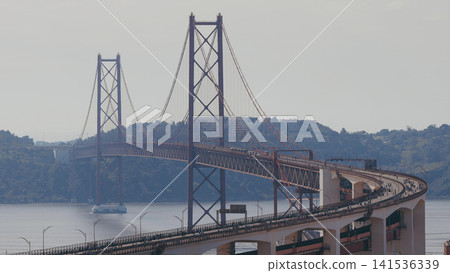 Running Lisbon half marathon crossing the 25 of April bridge over the Tagus river aerial view from above. Running Lisbon half marathon crossing the 25 of April bridge over the Tagus river aerial view from above. 141536339