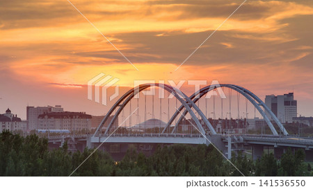 Sunset timelapse above the Bridge with the transport and clouds on the background. Central Asia, Kazakhstan, Astana Sunset timelapse above the Bridge with the transport and clouds on the background. Central Asia, Kazakhstan, Astana 141536550