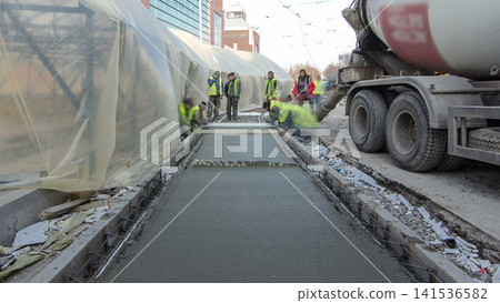 Pouring ready-mixed concrete after placing steel reinforcement to make the road by concrete mixer timelapse hyperlapse. Pouring ready-mixed concrete after placing steel reinforcement to make the road by concrete mixer timelapse hyperlapse. 141536582