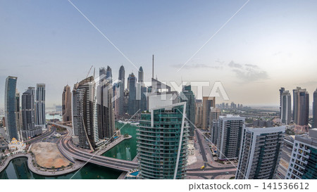 Aerial view of Dubai Marina residential and office skyscrapers with waterfront night to day timelapse Aerial view of Dubai Marina residential and office skyscrapers with waterfront night to day timelapse 141536612