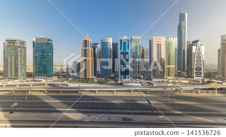 Aerial view of Jumeirah lakes towers skyscrapers all day timelapse with traffic on sheikh zayed road. Aerial view of Jumeirah lakes towers skyscrapers all day timelapse with traffic on sheikh zayed road. 141536726