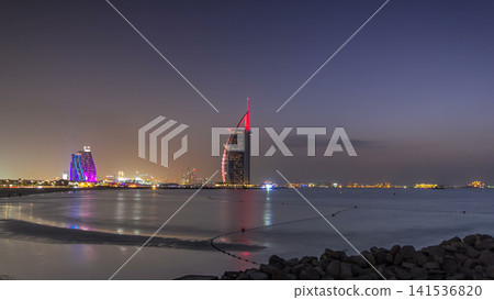 Dubai skyline with Burj Al Arab hotel day to night timelapse. Dubai skyline with Burj Al Arab hotel day to night timelapse. 141536820