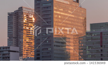 Sunrise reflected in Donaustadt Danube City modern skyscrapers and business centres timelapse in Vienna, Austria. Sunrise reflected in Donaustadt Danube City modern skyscrapers and business centres timelapse in Vienna, Austria. 141536949