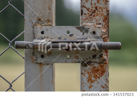Weathered metal latch on a rusty gate showing security and closure 141537023
