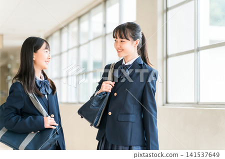 Junior high school and high school girls in uniforms walking in a school corridor Junior high school and high school girls in uniforms walking in a school corridor 141537649