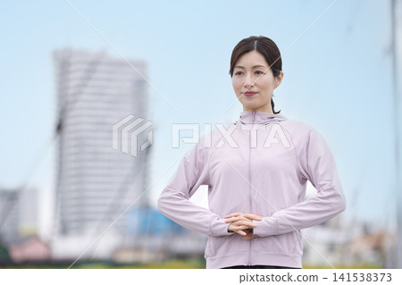 中年婦女身穿運動服伸展身體 中年婦女身穿運動服伸展身體 141538373