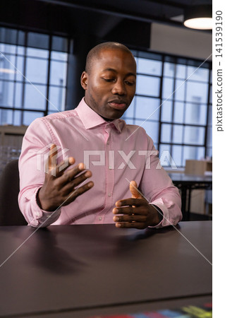 African american man presenting near grid-window conference table and checking watch African american man presenting near grid-window conference table and checking watch 141539190